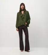 Pantalón flare de poliuretano con diseño de cinco bolsillos, trabillas para cinturón, cierre frontal y recortes horizontales en las rodillas. Presenta un corte ajustado en la parte superior con piernas levemente acampanadas hacia el ruedo.