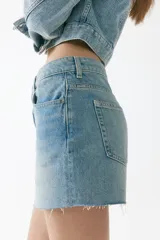 Short de cinco bolsillos en denim de algodón rígido, con tiro alto y bajo deshilachado.
