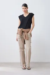 Remera verde pistacho de corte recto, con cuello en V y botones decorativos en los hombros.