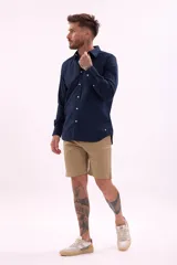 Bermuda de lino color beige, corte recto, con bolsillos laterales y traseros.