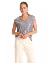 Blusa sin mangas con escote en V, confeccionada completamente en lentejuelas color dorado. Cuenta con forro interno a tono y un corte recto y holgado.