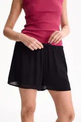 Short fluido de viscosa color negro, con cintura elastizada y cordón ajustable.
