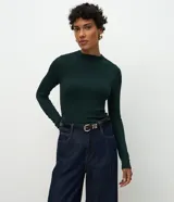 Blusa de manga larga con diseño ajustado, confeccionada en tejido acanalado de viscosa con elastano. Presenta cuello redondo y sisas raglán.