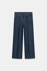 Jeans wide leg de tiro alto en color azul oscuro, con trabillas en la cintura, diseño de cinco bolsillos, nervios delanteros marcados y pespuntes a contraste. Cuenta con cierre frontal de cremallera y botón metálico.