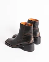 Botín de cuero con estampado de piel de serpiente en tonos blanco y negro, con puntera cuadrada y tacón bloque bajo.