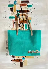 Bolso shopper Verona de cuero agamuzado color turquesa, con asas de hombro en tono dorado. Cuenta con diseño espacioso, interior sin forro con bolsillo y detalle de arte con firma de Carolina de Cunto.