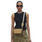 Cartera bandolera Marc Jacobs modelo The Snapshot, color tostado con herrajes dorados y logo frontal metálico. Incluye correa ajustable con diseño de cinta tejida y cierre superior.