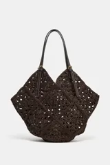Bolso formato shopper de color marrón con cuerpo trenzado y diseño geométrico. Cuenta con doble asa de hombro en combinación de materiales y compartimento interior extraíble con cremallera.