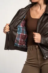 Campera bomber de cuero sintético marrón, con cierre frontal, cuello camisero, bolsillos laterales y elástico en los puños y la cintura.