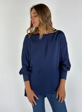 Blusa azul marino de mangas largas con puños abotonados y cuello redondo con detalle de volados.