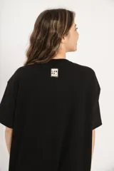 Vestido corto negro de corte holgado y mangas cortas. Tejido de punto acanalado.