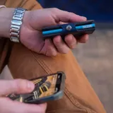 Billetera tipo tarjetero de cuero negro con caja de aluminio interna y sistema de deslizamiento para tarjetas. Cuenta con cierre mediante broche a presión.