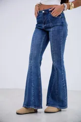 Jean de corte oxford con tiro medio-alto, confeccionado en denim azul con costuras verticales frontales que estilizan la silueta.