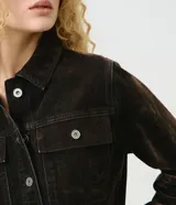 Campera ajustada de jean con acabado aterciopelado color marrón oscuro, cuello camisero, manga larga, cierre frontal con botones metálicos y bolsillos frontales con solapa.