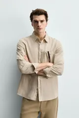 Camisa regular fit de manga larga con diseño a rayas verticales celestes y blancas. Cuenta con cuello abotonado, bolsillo de parche en el pecho y cierre frontal con botones.