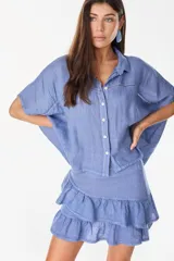 Minifalda amarilla confeccionada en lino italiano, de corte en A, con diseño de doble volado escalonado y detalles de terminación con bordado calado.