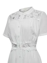 Vestido midi de lino orgánico y viscosa en color blanco, con cuello mao, mangas cortas y cierre frontal con botones. Presenta detalles de encaje en los hombros, el pecho y la cintura, además de forro interior a tono.