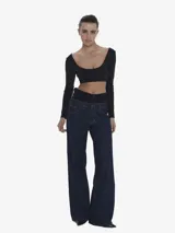 Jean de tiro alto con silueta wide leg y diseño de doble cintura superpuesta en contraste. Confeccionado en denim de algodón, presenta un calce holgado, bolsillos funcionales y cierre frontal con botón y cremallera.