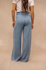 Pantalón wide leg de denim liviano en color celeste, con cintura elástica fruncida y cordón ajustable. Cuenta con bolsillos frontales aplicados.