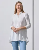 Camisola blanca de manga tres cuartos, marca Rio & Rian. Cuello con solapa y abertura central con botones. Manga con detalle fruncido.