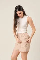 Short color beige con cintura elástica ajustable con cordón, bolsillos laterales y bolsillos cargo con solapa en los muslos.