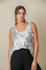 Blusa sin mangas confeccionada en tela cubierta de lentejuelas doradas y plateadas, con escote redondo y corte holgado.