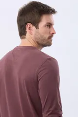 Remera de manga larga color bordó, con cuello redondo y estampado frontal de un paisaje montañoso con pinos y la palabra "LEGACY".