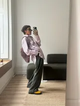 Camisa oversize de corte recto, confeccionada en tela de algodón a rayas verticales celestes y blancas. Presenta cuello clásico, cierre frontal con botones y mangas largas. El diseño destaca por una estampa frontal con palabras relacionadas al amor en diversos idiomas en color bordó.