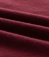 Suéter de punto en color bordó con corte slim, cuello polo y mangas largas. Presenta detalles de líneas blancas en contraste en el cuello y los puños, con acabado acanalado.