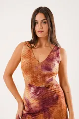 Vestido largo con estampado batik en tonos marrones y borgoña, escote en V, sin mangas y abertura lateral.