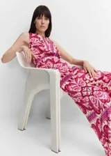 Mono largo de satén con estampado cachemir en tonos rosa y blanco. Tiene cuello redondo con abertura en forma de lágrima, sin mangas y corte recto.