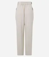 Pantalón zanahoria de mujer confeccionado en tela airflow color azul marino, con trabillas en la cintura, cinturón con hebilla, pliegues y elástico en la espalda.