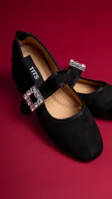 Chatitas negras de gamuza con correa sobre el empeine y hebilla con strass.