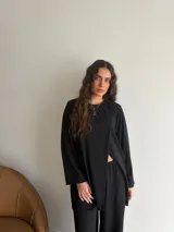 Conjunto de dos piezas color gris melange, confeccionado en tela de lanilla, compuesto por un buzo de manga larga con diseño cruzado al frente y un pantalón largo de corte holgado y tiro alto.