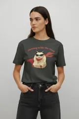 Remera de algodón color gris oscuro, con cuello redondo y manga corta. Presenta un estampado frontal de un hámster con lentes de sol y capa roja, acompañado por la frase 'flowing with the wind'.