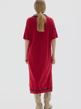 Vestido midi tejido color rojo, con cuello camisero azul marino y rayas blancas, escote en V con tres botones, manga corta con detalle de raya azul marino y aberturas laterales en el ruedo.