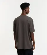 Remera de corte relaxed, confeccionada en algodón de tejido grueso con cuello redondo y mangas cortas.