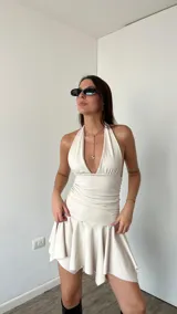 Vestido corto blanco con escote halter y falda con volados.