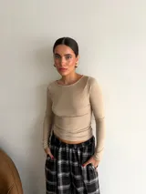 Remera de manga larga ajustada al cuerpo, con cuello redondo, confeccionada en tela de lanilla color beige.