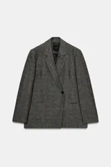 Blazer oversize de Zara confeccionado en hilatura con lana, con diseño de cuadros en tonos grises y líneas finas rojizas. Presenta cuello con solapa de muesca, cierre frontal cruzado con un botón, bolsillos de vivo en el delantero y forro interior.