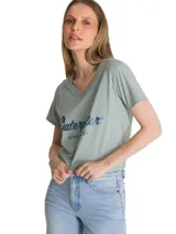 Remera de cuello en V color verde menta con estampa frontal del logo de la marca en tono azul metalizado. Presenta mangas cortas y un corte clásico.