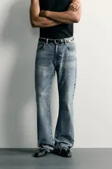 Jeans flare fit de hombre confeccionados en denim de algodón color azul con efecto lavado y roturas. Presentan diseño de cinco bolsillos, efecto salpicaduras de pintura en toda la prenda y bajo con acabado irregular.