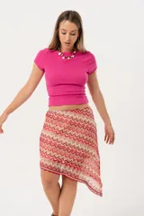 Minifalda asimétrica de crochet con diseño de ondas en tonos rojo, rosa y beige.