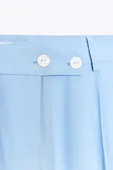 Pantalón celeste de tiro alto con pinzas delanteras, bolsillos laterales y falsos bolsillos traseros. Pierna ancha y cierre frontal con cremallera y botones.