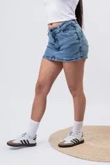 Short pollera de denim en lavado azul medio clásico, con diseño de mini falda en el frente y short incorporado.