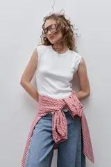 Remera sin mangas de silueta entallada y corte al cuerpo, confeccionada en algodón elastizado con textura acanalada y escote redondo.