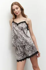 Short de pijama de satén con estampado animal print tipo cebra, con elástico en la cintura y detalle de puntilla negra en el ruedo.