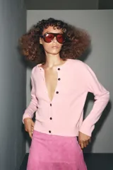 Chaqueta de tejido de punto color verde musgo, de corte cropped, con cuello redondo y cierre frontal de botones oscuros.