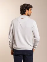 Sweater de punto en color gris claro, con cuello alto y medio cierre frontal. Presenta puños y ruedo acanalados para un ajuste cómodo.