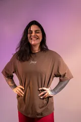 Remera oversize marrón de algodón elastizado con estampado en la espalda que incluye el texto "Crazy Hermod movement" y un diseño de zapatilla alada.